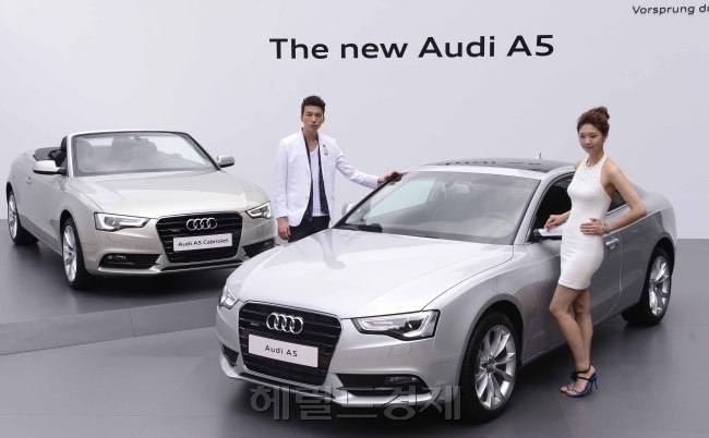 Models showcase the New Audi A5 (right) and the New Audi A5 Cabriolet, a convertible, during an unveiling event in downtown Seoul on Monday. The carmaker’s updated A5 series feature high-end technologies and more powerful engines.  Park Hae-mook/The Korea Herald