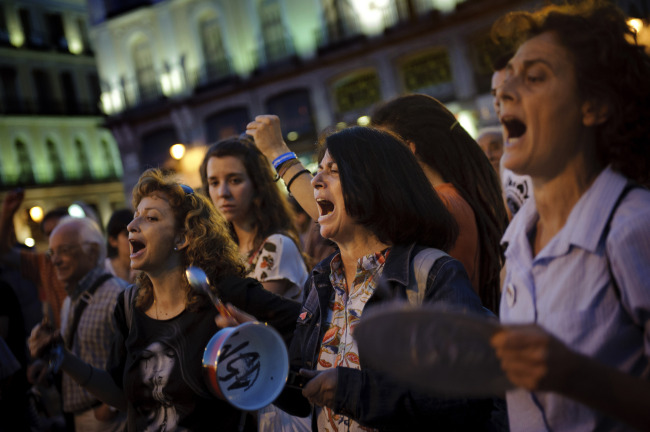 Demonstrators bang pots during a protest against the financial crisis and the latest government Economic measures in Sol square, Madrid, Sunday. AP-Yonhap News
