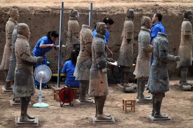 This picture taken on June 9 shows Chinese archaeologists at work in the extended excavation of the Pit One of the Terracotta Warriors and Horses Museum in Xian, as they measure and record the dimensions of the latest terracotta warrior find in Xian, China’s Shaanxi province.   (AFP-Yonhap News)