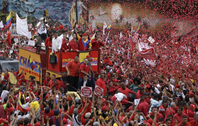 Venezuela’s President Hugo Chavez waves to the crowd while riding atop a truck upon his arrival to the elections office in Caracas on Monday.          (AP-Yonhap News)