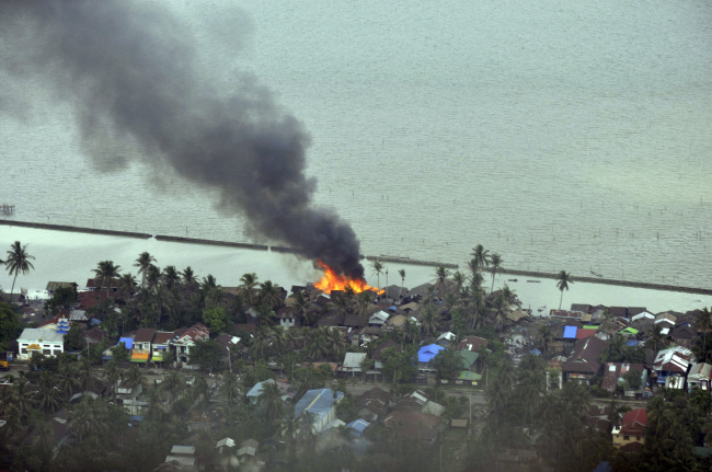 Smokes and flames are billowing from burning buildings at a village in Sittwe, capital of Rakhine state in western Myanmar, where sectarian violence are ongoing Monday.     (AP-Yonhap News)
