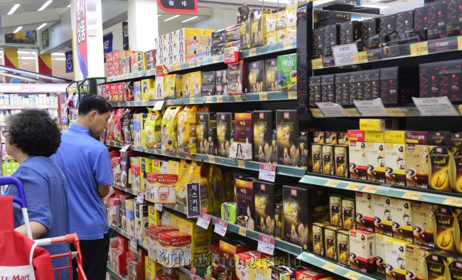 Customers purchase instant coffee mix at a discount store in Seoul on Tuesday. (Park Hae-mook/The Korea Herald)