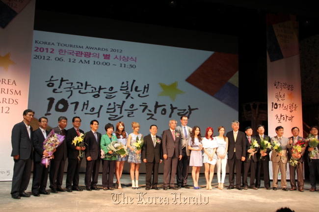 Culture, Sports and Tourism Minister Choe Kwang-shik (10th from left), Korea Tourism Organization CEO Lee Charm (11th from left), members of K-pop group KARA and other winners of the 2012 Korea Tourism Awards pose at the award ceremony on Tuesday in Seoul.  KTO