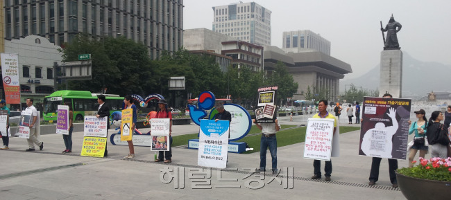 정치의 계절이다. 점심때만 되면 광화문 사거리에 일인시위자 들이 도열하여 억울한 사연을 호소하고 있다. 일인시위가 신고없이 때와 장소를 가리지 않고 가능해지자 광화문은 일인시위의 명소로 바뀌었다. <br />정희조 기자/checho@heraldm.com 120608
정치의 계절이다. 점심때만 되면 광화문 사거리에 일인시위자 들이 도열하여 억울한 사연을 호소하고 있다. 일인시위가 신고없이 때와 장소를 가리지 않고 가능해지자 광화문은 일인시위의 명소로 바뀌었다.
정희조 기자/checho@heraldm.com 120608
“지금 뭣들 하는 것이오!” 검을 들고 서 있는 이순신 장군의 굵은 목소리가 들리는 듯하다. 서울 광화문 광장은 매일 점심시간만 되면 ‘일인시위’하는 시위자들이 모인다. 모두 그럴 듯한 사연이 있다. 광화문 광장이 일인시위 명소가 된 듯 한 느낌이다.  정희조 기자/checho@heraldm.com
