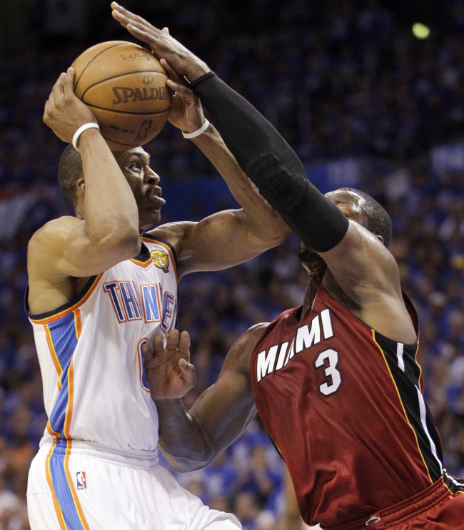 Oklahoma City Thunder guard Russell Westbrook drives on Miami Heat guard Dwyane Wade on Tuesday.  (AP-Yonhap News)