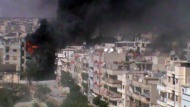 A handout image released by the Syrian opposition’s Shaam News Network shows smoke and flames rising from a building in the Khalidiyah neighborhood of the restive city of Homs on Tuesday.  (AFP-Yonhap News)