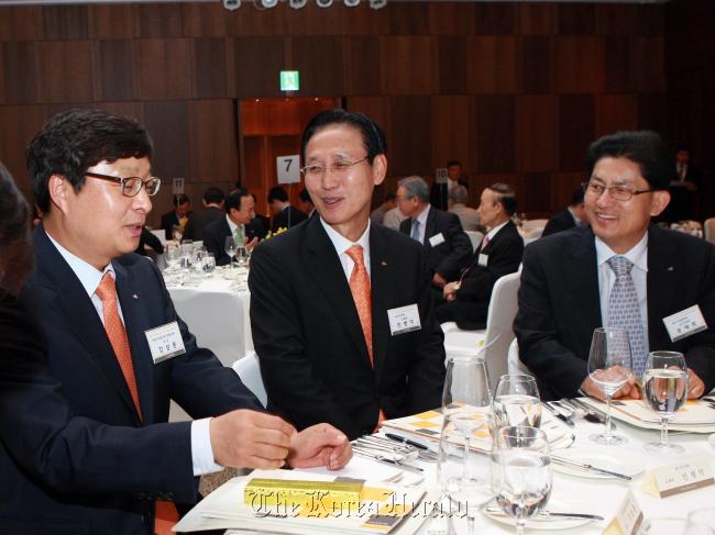KB Kookmin Bank CEO Min Byong-deok (center) talks with Korea Federation of Small and Medium Business executive vice chairman Song Jae-hee (right) and other CEOs at a seminar hosted by the bank for CEOs who succeeded or will succeed family business, at Hotel Shilla in central Seoul on Wednesday. (KB Kookmin Bank)