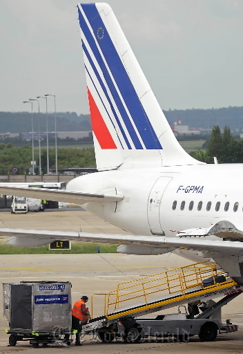 A ground crew employee loads baggage onto an Air France airplane at Orly Airport in Paris.  Bloombeg