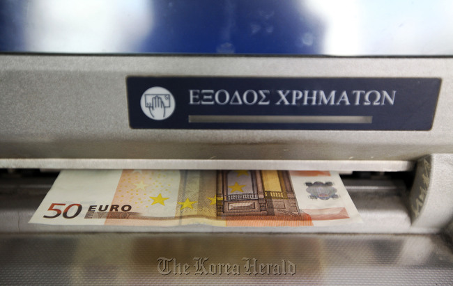 A 50 euro note is released from an automated teller machine in Athens.  Bloomberg