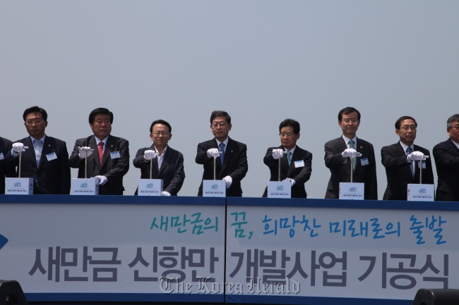 North Jeolla Province Gov. Kim Wan-joo (third from left), Prime Minister Kim Hwang-sik (fourth from left), Vice Land Minister Han Man-hee (sixth from left) and other high ranking officials press the symbolic button during the groundbreaking ceremony on Thursday.    Land Ministry