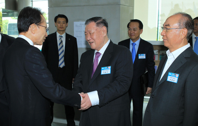 President Lee Myung-bak shakes hands with Hyundai Motor Group chairman Chung Mong-koo at a ceremony celebrating the 50th anniversary of the Korea Trade-Investment Promotion Agency at the agency’s headquarters in southern Seoul on Thursday. At right is Sohn Kil-seung, honorary chairman of SK Telecom. (Chung Hee-cho/The Korea Herald)