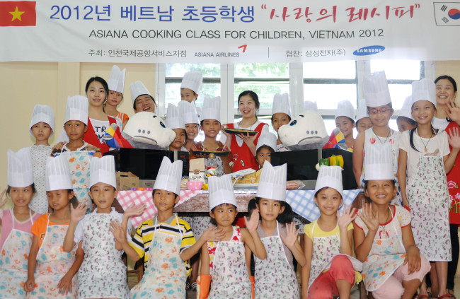 삼성전자와 아시아나항공이 손잡고 베트남 아이들에게 ‘사랑의 레시피’를 전달했다. 아시아나 직원들은 14~15일 베트남 하노이 남서쪽 28㎞ 탕와이 현에 위치한 NGO단체인 한ㆍ베 협력센터를 방문해 현지 어린이 260여명과 과자ㆍ피자를 만드는 즐거운 시간을 가졌다. 삼성전자는 오븐 30대 및 조리기구를 무상 증정했고, 오븐 쿠킹클래스 운영 및 조리 노하우를 전수했다.   [사진제공=아시아나항공]