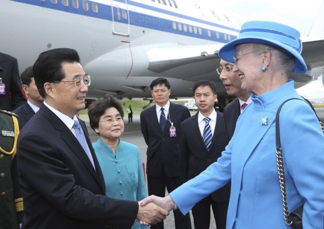 Chinese President Hu Jintao (left) and his wife Liu Yongqing are welcomed by Denmark’s Queen Margrethe II (right) upon their arrival in Copenhagen on Thursday.  Xinhua-Yonhap News