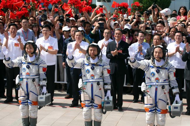 Mission commander Jing Haipeng (right), a veteran astronaut who has gone to space twice already, together with fellow astronauts Liu Wang (center) and Liu Yang, China’s first female astronaut, as they wave to the crowd prior to boarding the Shenzhou-9 spacecraft ― China’s fourth manned space mission ― which blasts off from the Jiuquan space base, northwest China’s Gansu province in the remote Gobi desert on Saturday.  (AFP-Yonhap News)