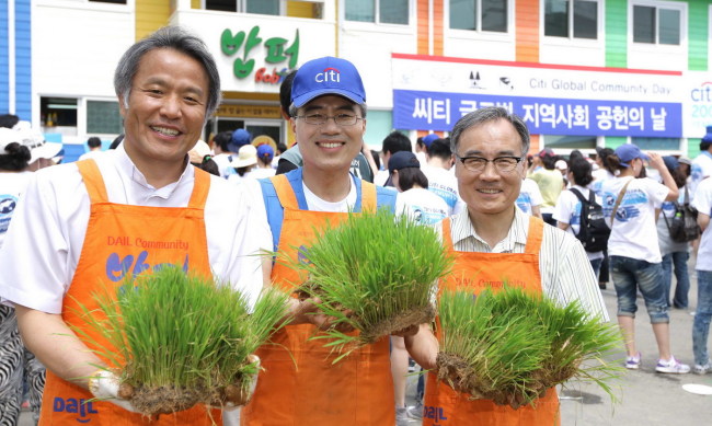 Citibank Korea CEO Ha Yung-ku (center) poses with leaders of charity groups on Saturday at a voluntary rice-planting event held under the slogan “Green Citi, Clean City”  to celebrate the bicentennial anniversary of Citigroup, in central Seoul. (Yonhap News)