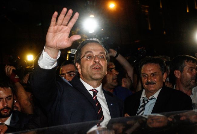 New Democracy party leader, Antonis Samaras (center), waves at supporters as he leaves the new office of the New Democracy conservative party election campaign kiosk near the Greek Parliament, after his party came first in the national Greek's election, in central Athens, on Sunday. (AFP-Yonhap News)