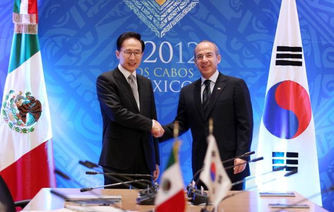 President Lee Myung-bak shakes hands with Mexican President Felipe Calderon during their summit in Los Cabos, Mexico, Sunday.  (Yonhap News)