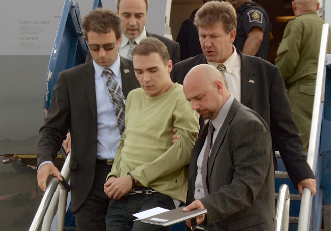 <YONHAP PHOTO-0816> In this photo provided by Montreal Police, Luka Rocco Magnotta is taken by police from a Canadian military plane to a waiting van on Monday, June 18, 2012, in Mirabel, Quebec. Magnotta, the suspect in the killing and dismemberment of a Chinese student, returned to Canada via military transport from Germany, where he was arrested this month. (AP Photo/Montreal Police)/2012-06-19 12:16:56/ <저작권자 ⓒ 1980-2012 ㈜연합뉴스. 무단 전재 재배포 금지.>
In this photo provided by Montreal Police, Luka Rocco Magnotta is taken by police from a Canadian military plane to a waiting van in Mirabel, Quebec on Monday.   AP-Yonhap News