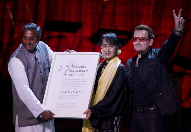 General Secretary of Amnesty International Salil Shetty (left) and Irish singer Bono hand Myanmar opposition leader Aung San Suu Kyi the Amnesty International’s Ambassador of Conscience award in Dublin on Monday.  (AP-Yonhap News)