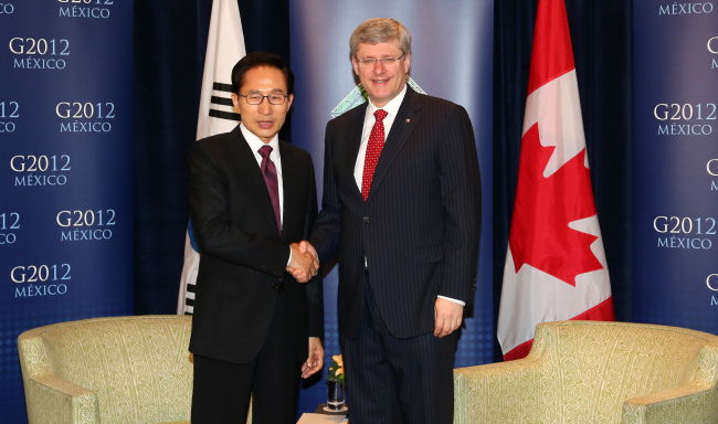 President Lee Myung-bak shakes hands with Canadian Prime Minister Stephen Harper during their talks in Los Cabos, Mexico, on Monday.  Yonhap News