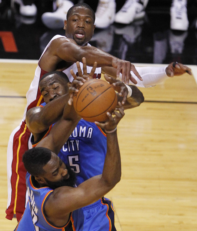 Miami Heat shooting guard Dwyane Wade (top), Oklahoma City Thunder center Kendrick Perkins (center) and guard James Harden go after a rebound during the NBA Finals in Miami on Tuesday.  (AP-Yonhap News)