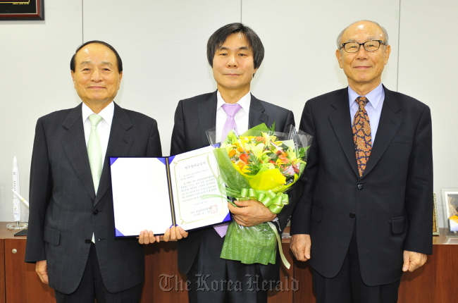 Ihm Ji-soon (center), chair professor at the department of physics and astronomy of Seoul National University, poses with Oh Myung (left), chairman of the S-Oil Science Prodigy and Culture Foundation, and Chung Kil-saeng, president of the Korean Academy of Science and Technology, after winning the 300 million won Leading Scientist of the Year Fellowship, the biggest academic award in basic science here offered by the oil refiner, at a ceremony in Seoul on Wednesday.  (S-Oil)