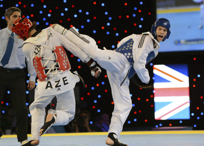 Great Britain’s Aaron Cook (right) aims a kick on his way to controversially beating Ramin Azizov of Azerbaijan during the European Taekwondo Championships at the Manchester Regional Arena, Manchester, England.  (AP-Yonhap News)