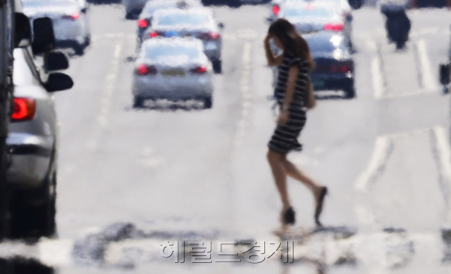 올들어 가장 무더운 날씨를 보이는 19일 오후 연일 이어지는 폭염으로 인해 여의도일대의 도로가 지글지글 끓고 있다. 박해묵 기자/mook@heraldm.com
뜨거워진 대기(大氣)는 대지(大地)를 지글지글 끓게 한다. 땅에서 뭔가 꿈틀꿈틀 올라온다. ‘아지랑이’다. 햇빛이 강하게 내리쬘 때 공기가 공중에서 아른아른 움직이는 현상이다. 연일 30도를 넘어서면서 도로가 프라이팬이다. 계란을 쫙 깨 올려놓으면 계란프라이라도 될 것 같다. 21일 서울 여의도의 한 도로 모습이다.  박해묵 기자/mook@heraldm.com