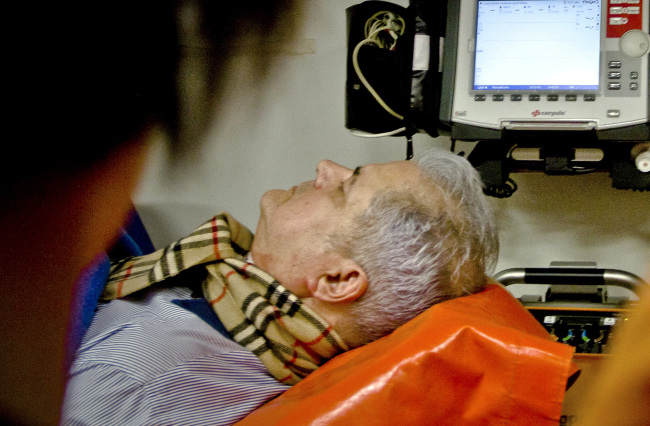 Paramedics attend to former Romanian Prime Minister Adrian Nastase in an ambulance in Bucharest on Wednesday. (AP-Yonhap News)