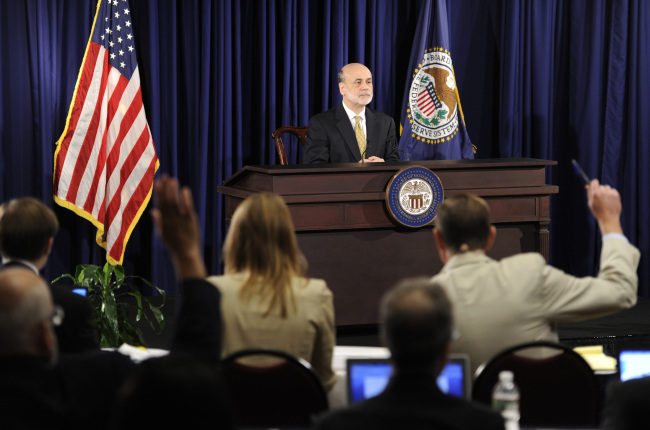 Journalists raise their hands to be called on as Federal Reserve Board Chairman Ben Bernanke attends a press conference at the conclusion of the Federal Open Market Committee’s two-day meeting in Washington, D.C., Wednesday.   (UPI-Yonhap News)