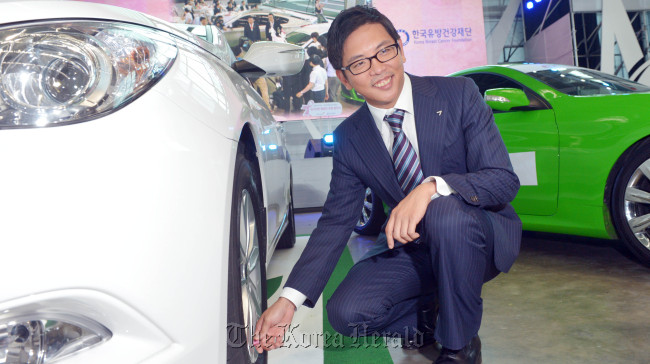 Kumho Tire vice president Park Se-chang poses with the “ecowing S,” which increases fuel efficiency of vehicles, at an Asiana Airlines hangar in Incheon on Thursday. (Kim Myung-sub/The Korea Herald)