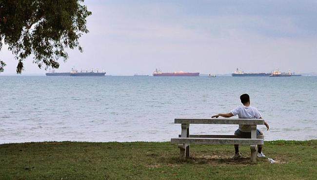 A man on a bench on the seashore.   Straits Times