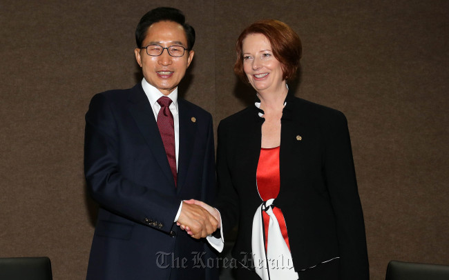 President Lee Myung-bak shakes hands with Australian Prime Minister Julia Gillard during their talks in Brazil on Wednesday.  (Yonhap News)