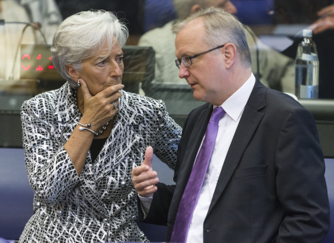 International Monetary Fund Managing Director Christine Lagarde (left) talks with European Economic and Monetary Affairs Commissioner Olli Rehn during the Eurogroup finance ministers’ meeting in Luxembourg, on Thursday.  (Xinhua-Yonhap News)