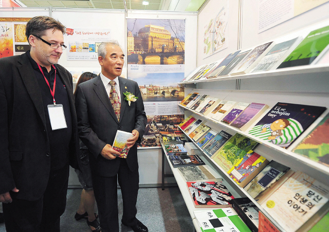 Ambassador Jaroslav Olsa Jr. (left) and Korean Culture Minister
of Culture Choe Kwang-sik view the Czech book stand at COEX
Seoul International Book Fair last week. (Czech Embassy)