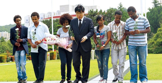 ankuk University of Foreign Studies president Park Chul (center) and descendants of Ethiopian soldiers who fought in the Korean War
pay their respects at the U.N. Memorial Cemetery in Busan recently, ahead of the 62nd anniversary of the Korean War on Monday.
(Bradly Scott Pocock)