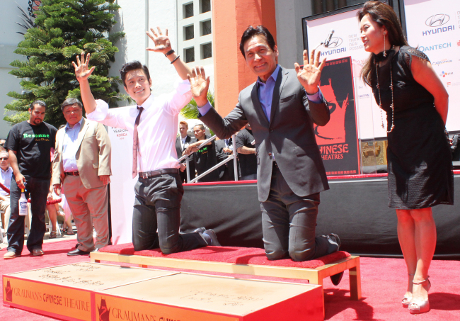 Korean actors Lee Byung-hun (left) and Ahn Sung-ki pose for a photo at the handprint ceremony in front of Grauman’s Chinese Theater in Hollywood on Saturday.  (Yonhap News)