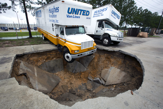 A truck hangs over the edge of a sinkhole in Salt Springs, Florida, Monday. (AP-Yonhap News)