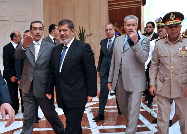 An Egyptian official welcomes the new president-elect, the Muslim Brotherhood’s Mohamed Morsi, during his visit to his new office at the Al-Ittihadiya presidential palace in Cairo on Monday.   (AFP-Yonhap News)