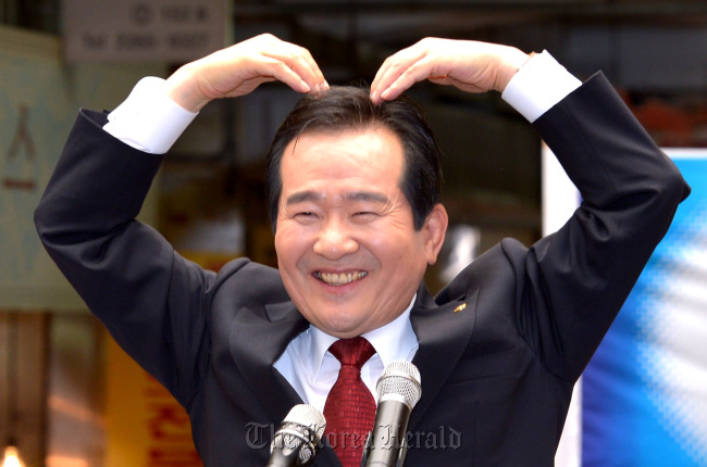 Rep. Chung Sye-kyun of the Democratic United Party makes the shape of a heart as he announces his presidential bid in a Seoul marketplace Tuesday.  (Park Hyun-koo/The Korea Herald)