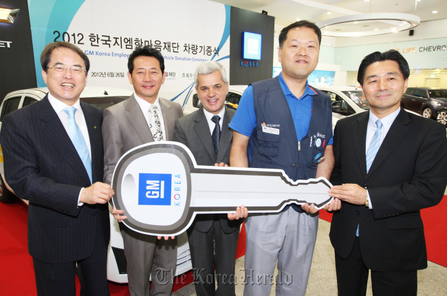GM Korea CEO Sergio Rocha (third from left) attends a ceremony to donate 35 cars to welfare centers at the carmaker’s headquarters in Bupyeong, west of Seoul, on Tuesday.  (GM Korea)