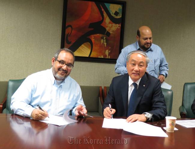 GS E&C CGO Woo Sang-ryong (right) and Saudi Aramco vice president Abdulaziz Al-Judaimi pose before signing a contract to build a petrochemical plant in Saudi Arabia.  GS E&C
