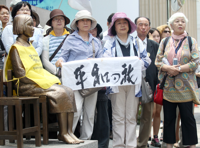 A group of Japanese civic activists protest in front of the Japanese Embassy in central Seoul on Wednesday demanding their government formally apologize for the wartime sex slavery of Korean women during its colonial rule. They joined the weekly protest hosted by Korean activists and former “comfort women.”  (Yonhap News)
