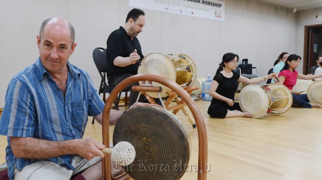 Grammy winner Henry Kaiser plays a jing, a traditional Korean percussion instrument, at the National Gugak Center in Seoul, Friday.   (Chung Hee-cho/The Korea Herald)