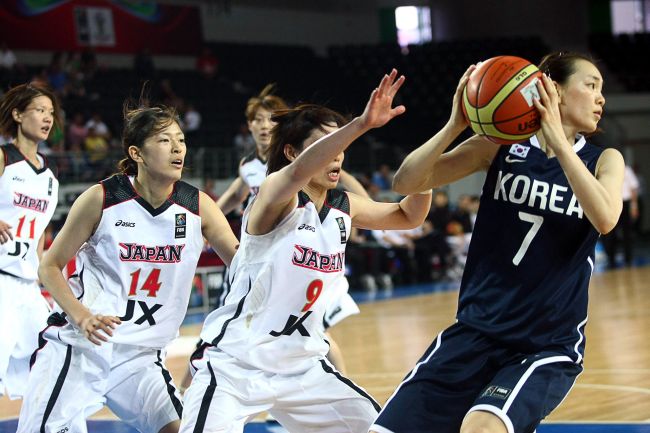 <YONHAP PHOTO-0329> South Korea's Cheajin Han (R) vies with Japan's Emi Kudeken (C) and Komiko Yamadan (L) during their 2012 women's FIBA Olympic Qualifying Tournament match in Ankara on June 30, 2012. AFP PHOTO / ADEM ALTAN../2012-07-01 05:52:38/ <저작권자 ⓒ 1980-2012 ㈜연합뉴스. 무단 전재 재배포 금지.>
Korea’s Han Chea-jin (right) looks to pass the ball against Japan.  AFP-Yonhap News