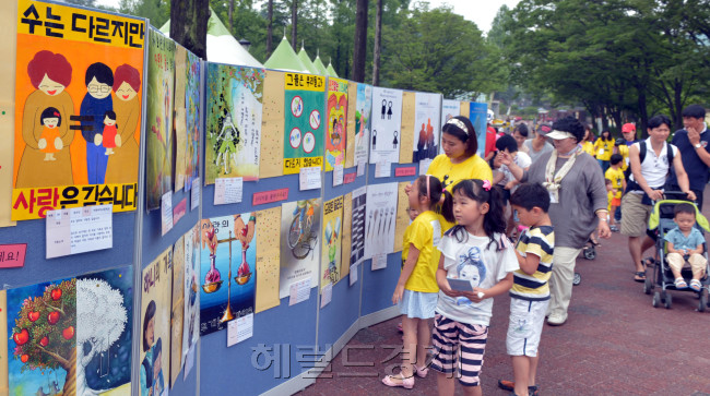 서울시는 1일 서울 능동어린이대공원에서 여성주간(1일~7일)개막행사를 열어 아이들이 한부모가족 개선인식 포스터를 보고 있다.<br />김명섭 기자 msiron@
서울시는 1일 서울 능동어린이대공원에서 여성주간(1일~7일)개막행사를 열어 아이들이 한부모가족 개선인식 포스터를 보고 있다.
김명섭 기자 msiron@