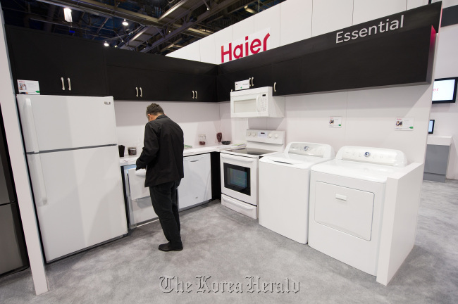 An attendee looks at durable goods made by the Haier Group at the International Consumer Electronics Show in Las Vegas, Nevada.  Bloomberg