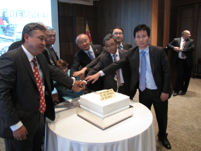 Ambassadors from the Commonwealth of Independent States help Belarusian Ambassador Natallia Zhylevich (seated) cut a celebratory cake for her country’s national day in Seoul on Thursday. (Kirsty Taylor/The Korea Herald)