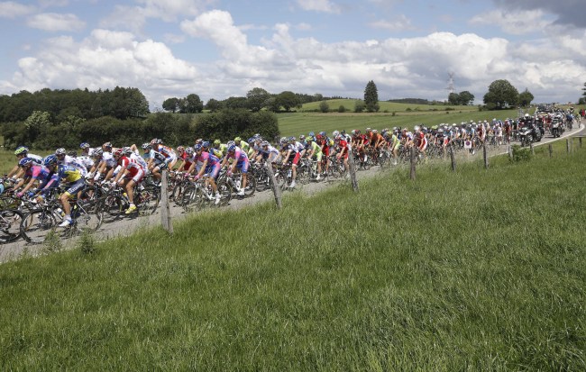Cyclists pass through fields during the first stage of the Tour de France on Sunday.  (AP-Yonhap News)