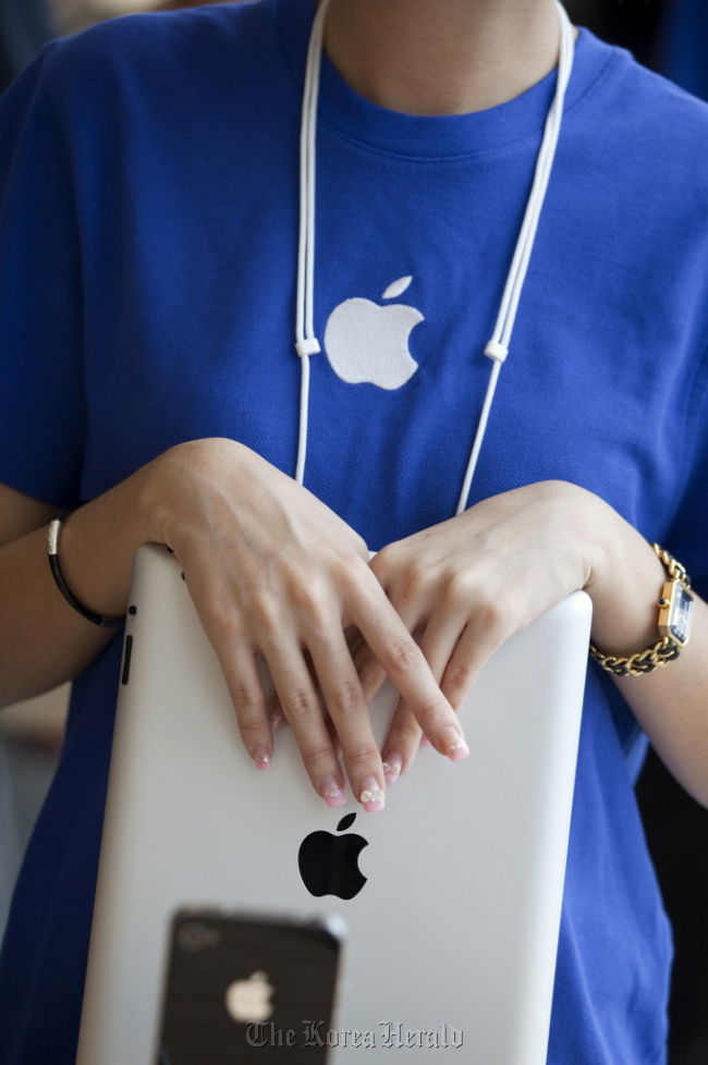 An Apple Inc. employee holds an iPad at the company’s new store in Hong Kong.  Bloomberg
